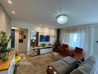 Sala de estar moderna com lareira e grandes janelas.