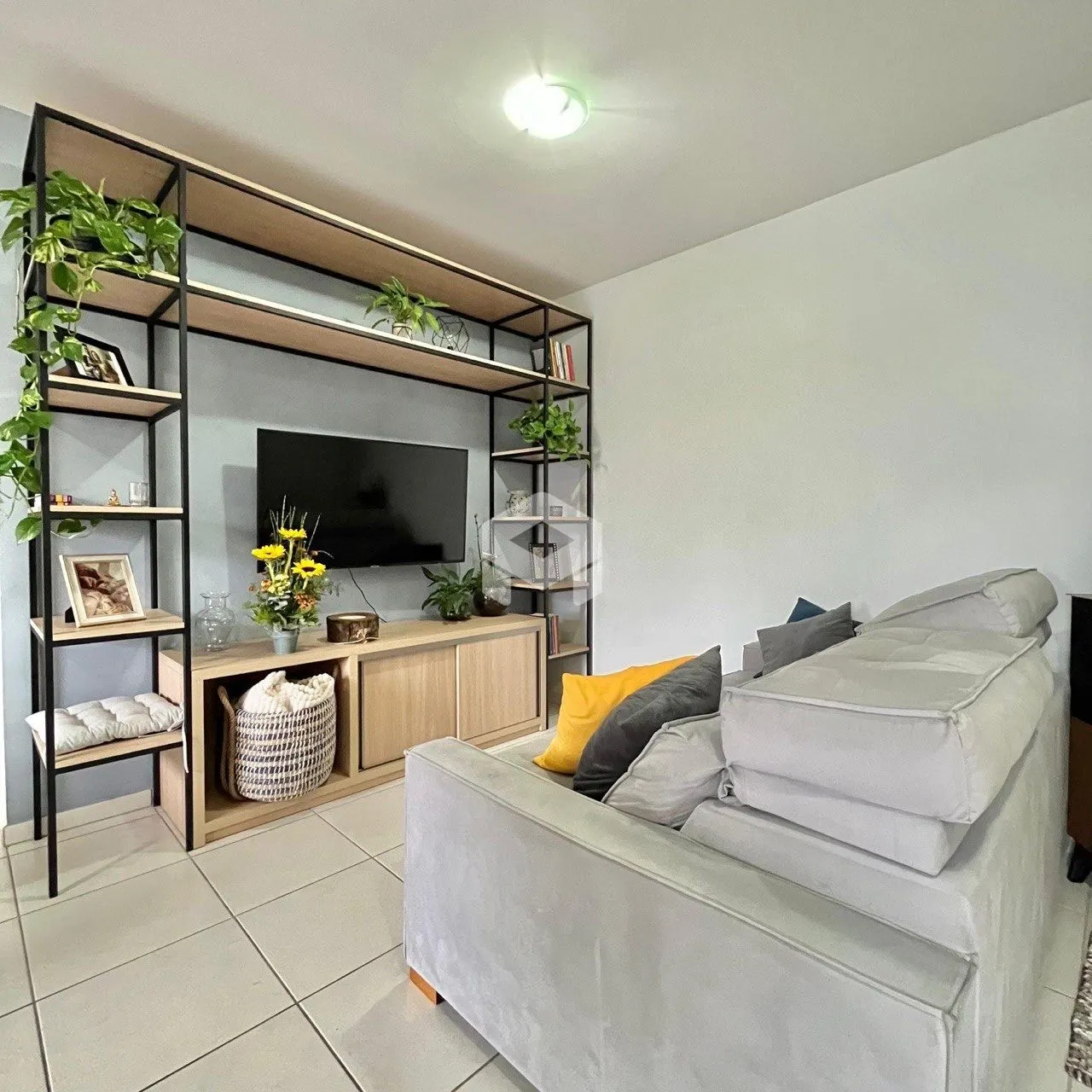 Sala de estar com sofá e estantes de madeira na residência.