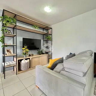 Sala de estar com sofá e estantes de madeira na residência.