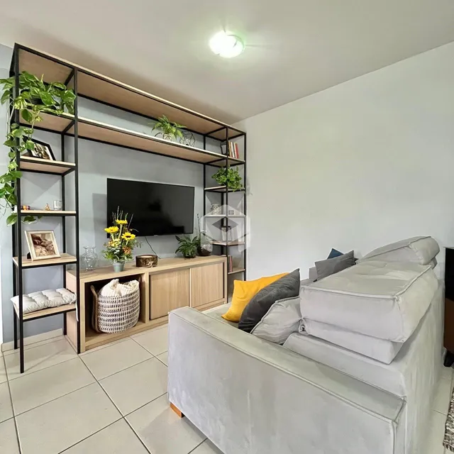 Sala de estar com sofá e estantes de madeira na residência.
