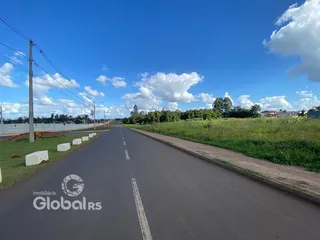 Vista de uma estrada rural com vegetação ao longo de uma paisagem aberta.