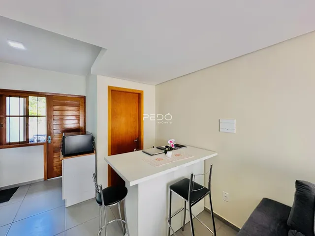 Vista de uma área comum com portas de madeira e um balcão branco.