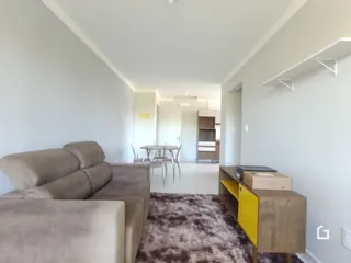 Imagem de uma sala de estar clara com sofá e corredor em um imóvel.
