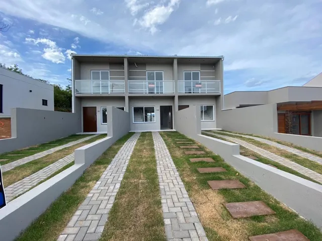 Fachada de um prédio residencial em Lajeado, Brasil, com jardim frontal e calçadas.