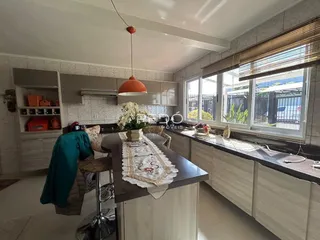 Vista da cozinha com armários e janela em um imóvel no Brasil.