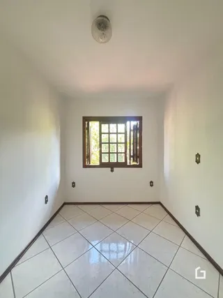 Corredor interno com piso de cerâmica e janela no ambiente.