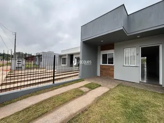 Fachada de uma casa moderna em Lajeado, Brasil, com cerca e jardim na frente.
