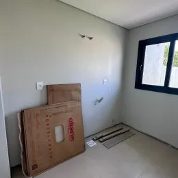Parede interna clara com caixas de papelão empilhadas em um ambiente.