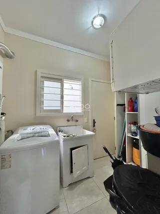 Foto de uma área de serviço com máquina de lavar e pia em um imóvel no Brasil.