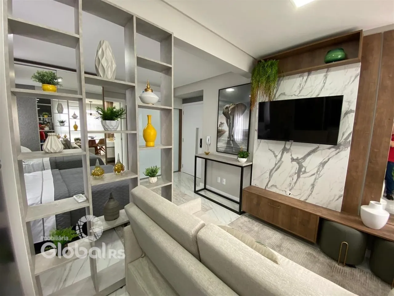 Sala de estar moderna com decoração de estantes e painel de mármore.