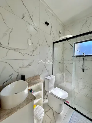 Foto de um banheiro moderno com revestimento em mármore branco.