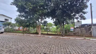 A fachada da propriedade em Lajeado, Brasil, mostra uma área pavimentada com árvores.