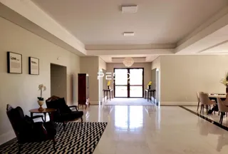 Sala de estar ampla com piso claro e paredes brancas.