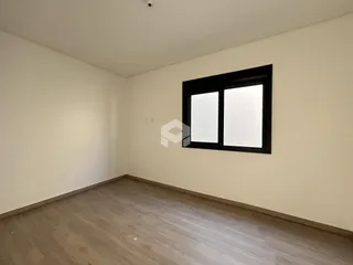Foto de um cômodo vazio com paredes claras e piso de madeira.
