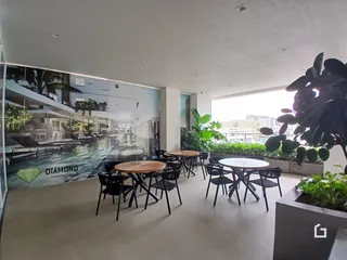 Ambiente interno com área de estar e disposição de mesas para refeições.