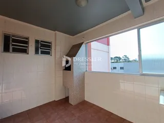 Interior de uma sala com paredes brancas e piso de cerâmica em Lajeado.