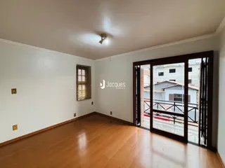Sala de estar com piso de madeira e porta de vidro.