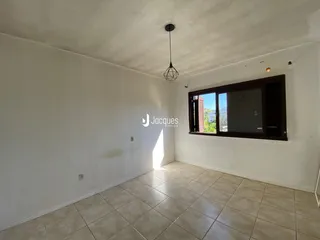 Ambiente interno com piso de cerâmica claro e janela de vista para o exterior.