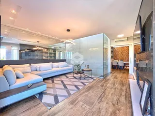 Sala de estar moderna com piso de madeira e grande sofá cinza.
