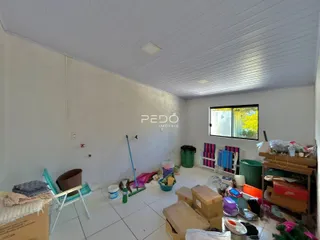 Interior de uma sala com paredes brancas e piso de cerâmica.