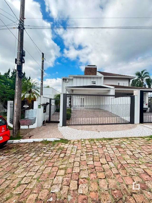 Fachada de uma residência em Lajeado, Brasil com portão de ferro.