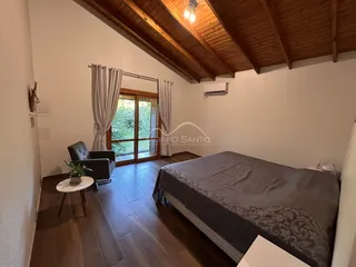 Quarto com cama grande e piso de madeira em um imóvel em Lajeado.