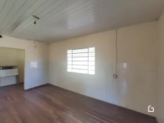 Vista interna de uma sala com piso de madeira clara.