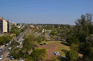 Vista aérea de uma área residencial com vegetação e terreno aberto.