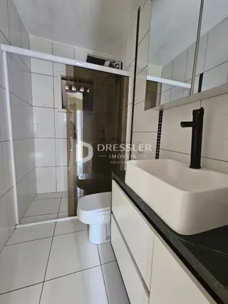 Foto de um banheiro com revestimento cerâmico branco.