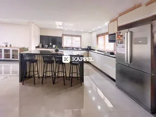 Esta é uma foto de uma cozinha moderna com ilha e armários escuros.