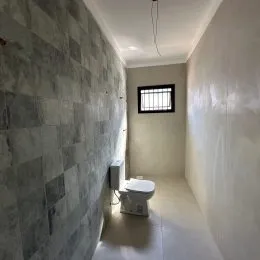 Foto de um corredor interno com paredes claras e piso claro.