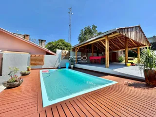 Foto de uma piscina e deck de madeira em uma propriedade.