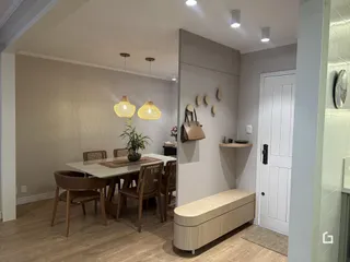 Foto de uma sala de jantar com mesa e cadeiras de madeira clara.
