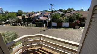 Vista externa de uma residência em Lajeado, Brasil, mostrando uma rua pavimentada e casas ao fundo.