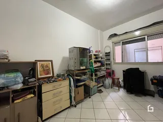 Vista interna de uma sala com paredes brancas e janela.