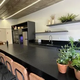 Foto de uma cozinha com bancada escura e armários escuros.