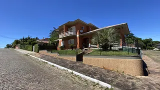 Fachada de uma casa de dois andares em Lajeado, Brasil, com telhado de telhas vermelhas e cerca frontal.