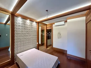 Quarto com cabeceira e parede decorada em madeira