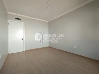 Ambiente interno com piso de madeira clara e paredes brancas.