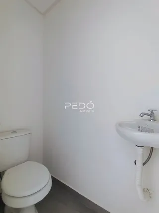 Foto de um banheiro com vaso sanitário e pia brancos.