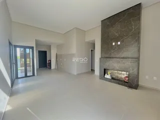Ambiente interno de uma sala de estar com parede de destaque em mármore cinza.