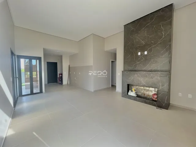 Ambiente interno de uma sala de estar com parede de destaque em mármore cinza.
