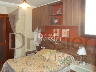 Quarto com cabeceira de madeira e armário em um imóvel no Brasil.