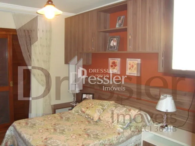 Quarto com cabeceira de madeira e armário em um imóvel no Brasil.