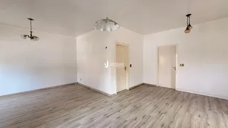 Ambiente interno com piso de madeira e paredes brancas.