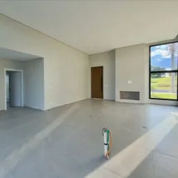 Espaço interno amplo com paredes brancas e piso claro.