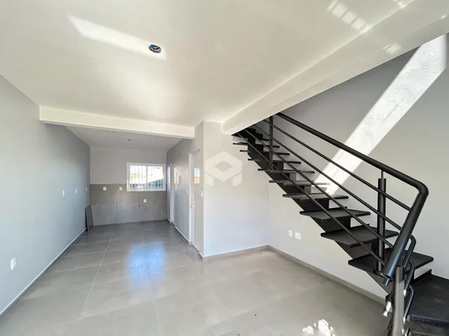 Corredor interno de uma residência com piso de cerâmica e escadaria.