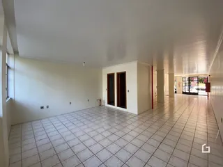 Corredor interno com piso de cerâmica e paredes brancas.