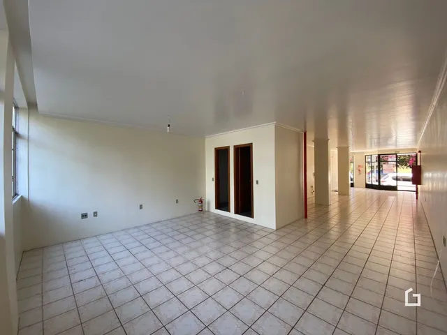 Corredor interno com piso de cerâmica e paredes brancas.