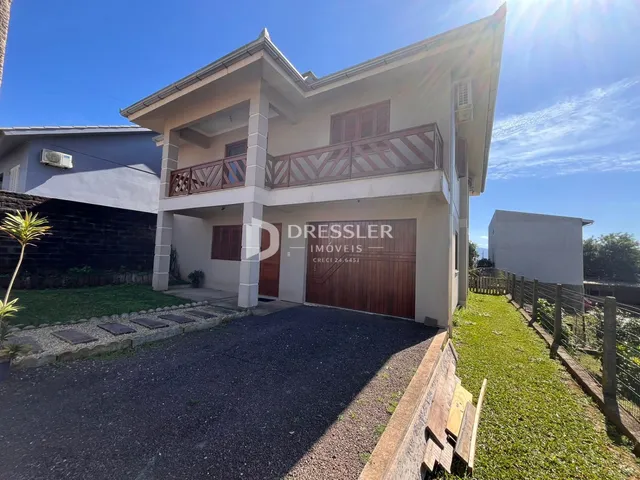 Fachada de uma casa em Lajeado, Brasil, com porta de garagem e cerca.
